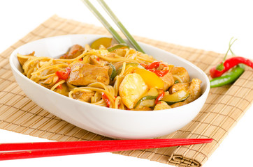 Stir-fried noodles with chicken and vegetables served in a bowl