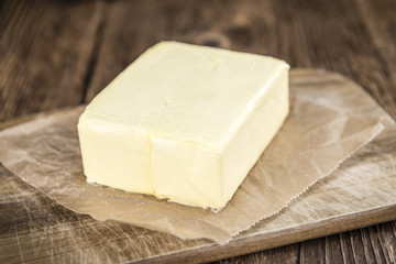 Piece of Butter on wooden background (selective focus)