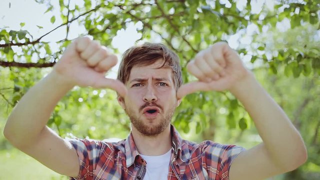 Closeup portrait of angry, unhappy, young handsome man showing thumbs down sign. Negative human emotions, facial expressions, feelings