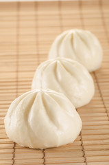 Chinese steamed buns on the bamboo mat background