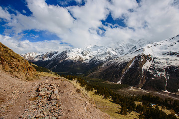 the mountain path on the background of snow-capped peaks