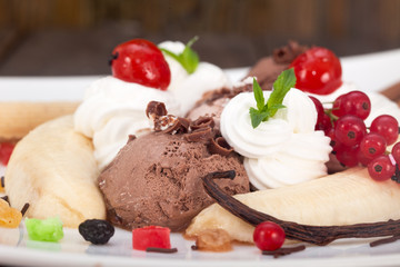 Delicious banana split ice cream dessert with whipped cream and berries