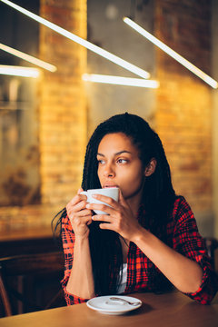 Young african woman drinking coffee
