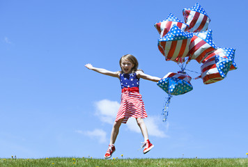 Cheerful American  girl with balloons jumping outside. 4th of July. Independence day. 