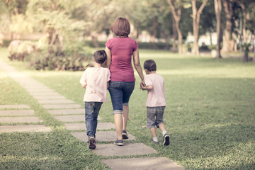 single mother walking in the park with sons