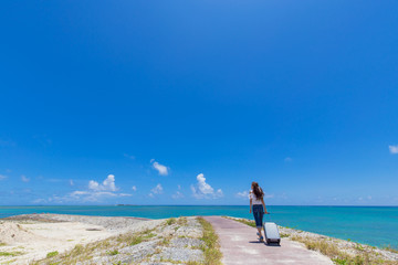 沖縄の海と旅をする女性