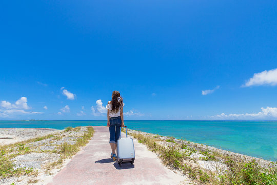沖縄の海と旅をする女性
