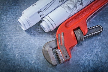 Monkey wrench rolled construction drawings on metallic backgroun