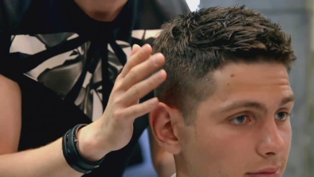 Master in stylish men's barbershop finish his work and look on haircut