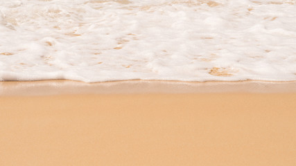 Beach. Soft white wave foam of the sea on sandy beach at Phuket, Thailand. Summer time at sea beach concept. Copy space for some text.