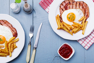 English breakfast with grilled ham, fried egg and french fries.