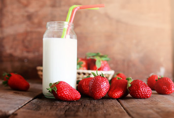 wooden table with strawberries and milk in a glass