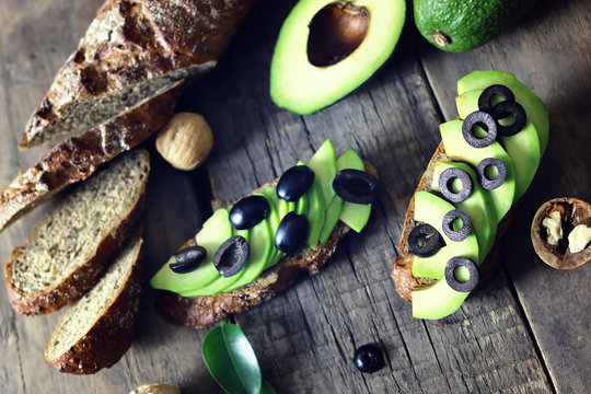 avocado bread olives on a wooden background