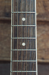Guitar neck on a wooden floor .