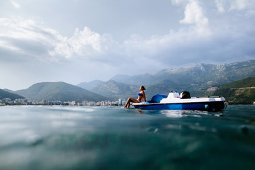 girl sunbathe in sea on paddle boat catamaran