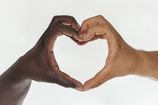 White and brown hands in heart shape. White background