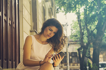 Young woman using smartphone outdoors.

