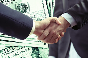 Business handshake on dollars background