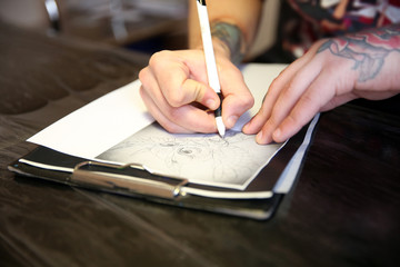 Male hand painting picture in notebook