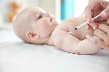 Professional pediatrician vaccinating baby, close up