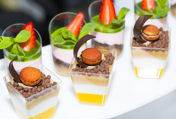 mini canapes in plastic cups decorated with edible flowers