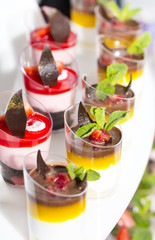 mini canapes in plastic cups decorated with edible flowers