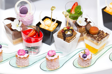 mini canapes in plastic cups decorated with edible flowers