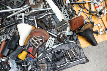 Old bicycle spare parts and accessories in heap offered for sale - obrazy, fototapety, plakaty