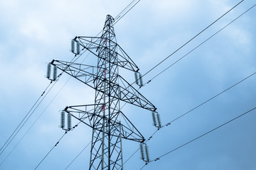 Electricity pylon with power lines against blue sky