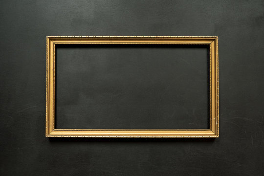 Horizontal gold thin picture frame on the black background with copy space