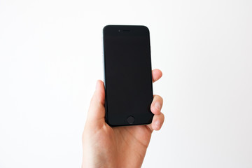 Hand holding black smartphone with blank screen