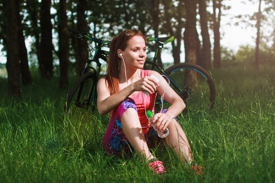 Sports woman with a bike and a phone