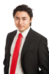 Attractive businessman in his 20s, wearing a black suit with a red tie, looking at camera. Standing against a white background.