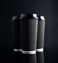 Luxury set of big take away cardboard paper cups closed with caps isolated on black and mirrored....