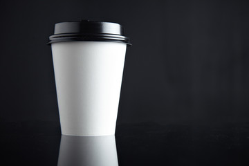 One take away white cardboard paper cup closed with caps isolated on left side and mirrored. Retail mockup presentation