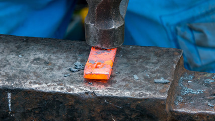 Detailed shot of metal being worked at a blacksmithing forge
