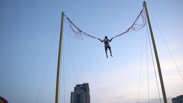 a Child on a Swing Against the Sky
