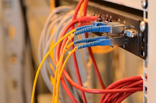 Fiber Optic cables connected to an optic ports and UTP Network cables connected to ethernet ports.