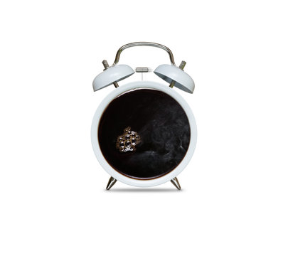 Kaffee und Wecker vor wei&szlig;em Hintergrund
