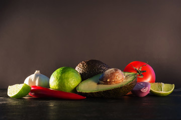 Ingredients for guacamole, avocado, lime, onion, garlic, tomato,