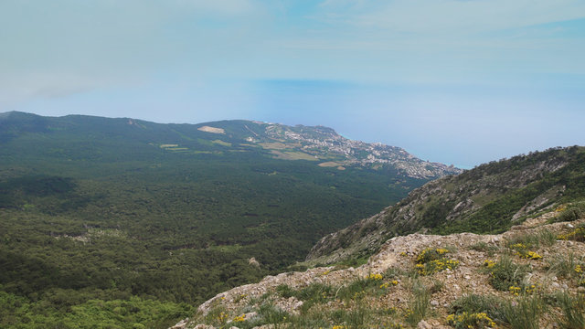 Panoramic view from the mountains to the sea, forest and settlements.