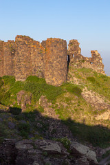Fototapeta na wymiar Amberd Fortress with ruined walls on green hill in Armenia