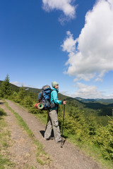 Obraz premium Hiking in the mountains with a backpack on a sunny summer day