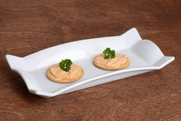 salmon pate crackers with parsley on a plate