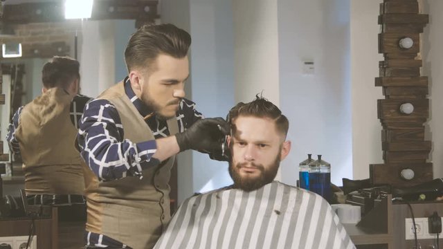 men's hairstyling and haircutting with hair clipper in a barber shop or hair salon
