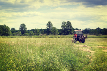 Old tractor on green field - vintage effect
