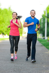 Runners training outdoors working out. City running couple jogging outside. City sport training in green park.