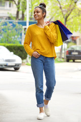 Stylish young black lady with shopping bags