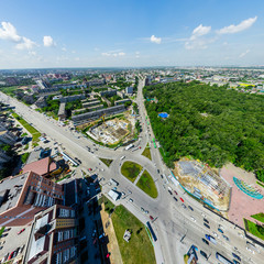 Aerial city view with crossroads and roads, houses, buildings, parks and parking lots, bridges. Urban landscape. Copter shot. Panoramic image.