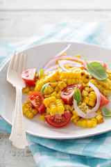 Salad with grilled corn, tomatoes and onion